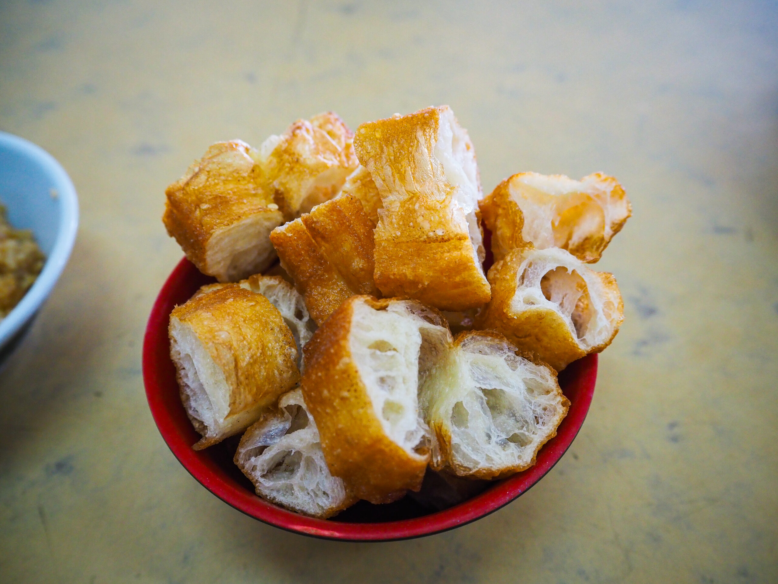 「油条をバクテーに浸して食べる様子」